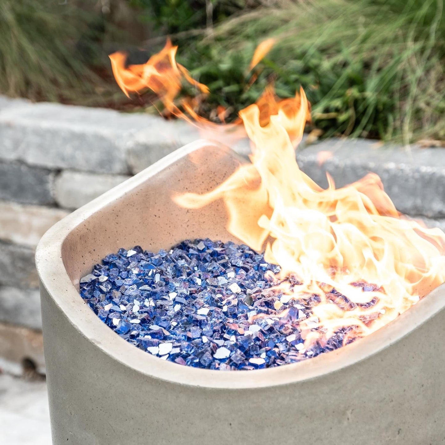 American Fyre Designs Wave 20-inch Fire Urn - Smoke - Lifestyle - Shown with Alpine Flame Sky Blue Fire Glass (Sold Separately)