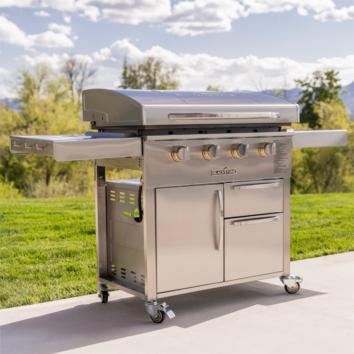 Blackstone Select 36-inch griddle with cabinet, on a patio with side shelves up