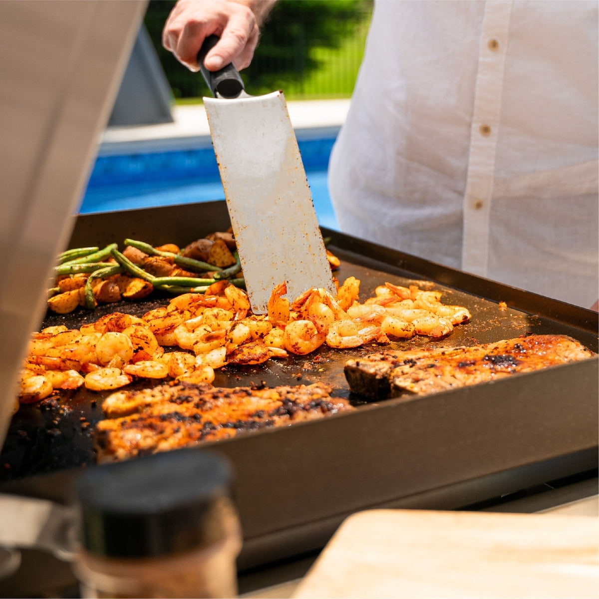 Blackstone Select 28-inch griddle with cabinet, shrimp and steak on the griddle plate