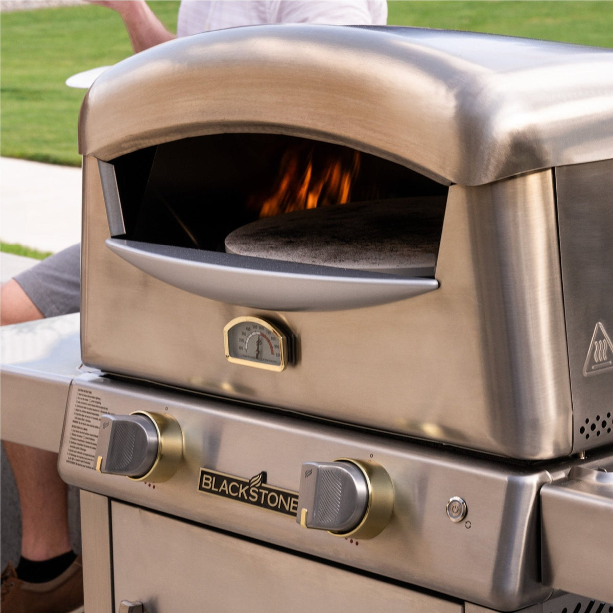 Blackstone Select pizza oven with cart, pizza baking with the flame lit