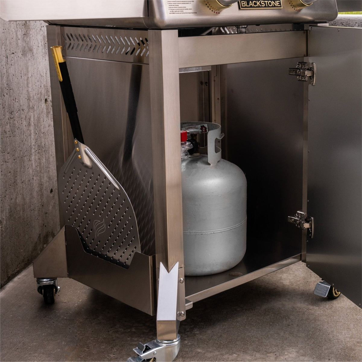 Blackstone Select pizza oven with cart, propane tank cabinet open