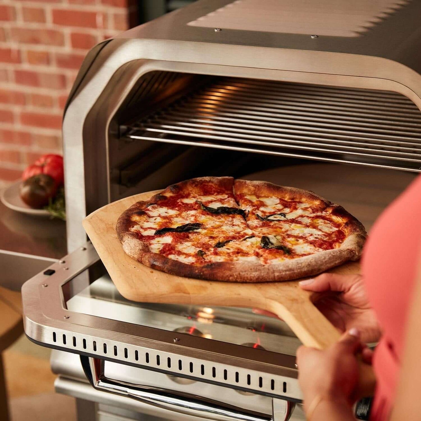 Blaze BLZ-26-PZOVN 26-Inch Built-In Outdoor Pizza Oven With Rotisserie - Taking Pizza Out of Oven - Detail